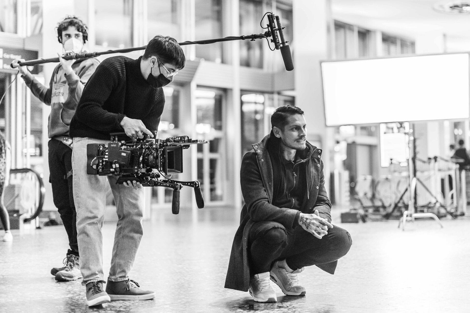 ORISONO camera operator and director in conversation between takes at an airport terminal set in Lucerne