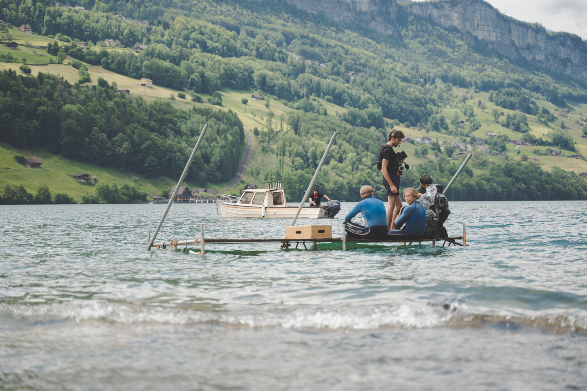 Underwater unit on a floating raft rig shooting wetsuit talent on a Swiss alpine lake