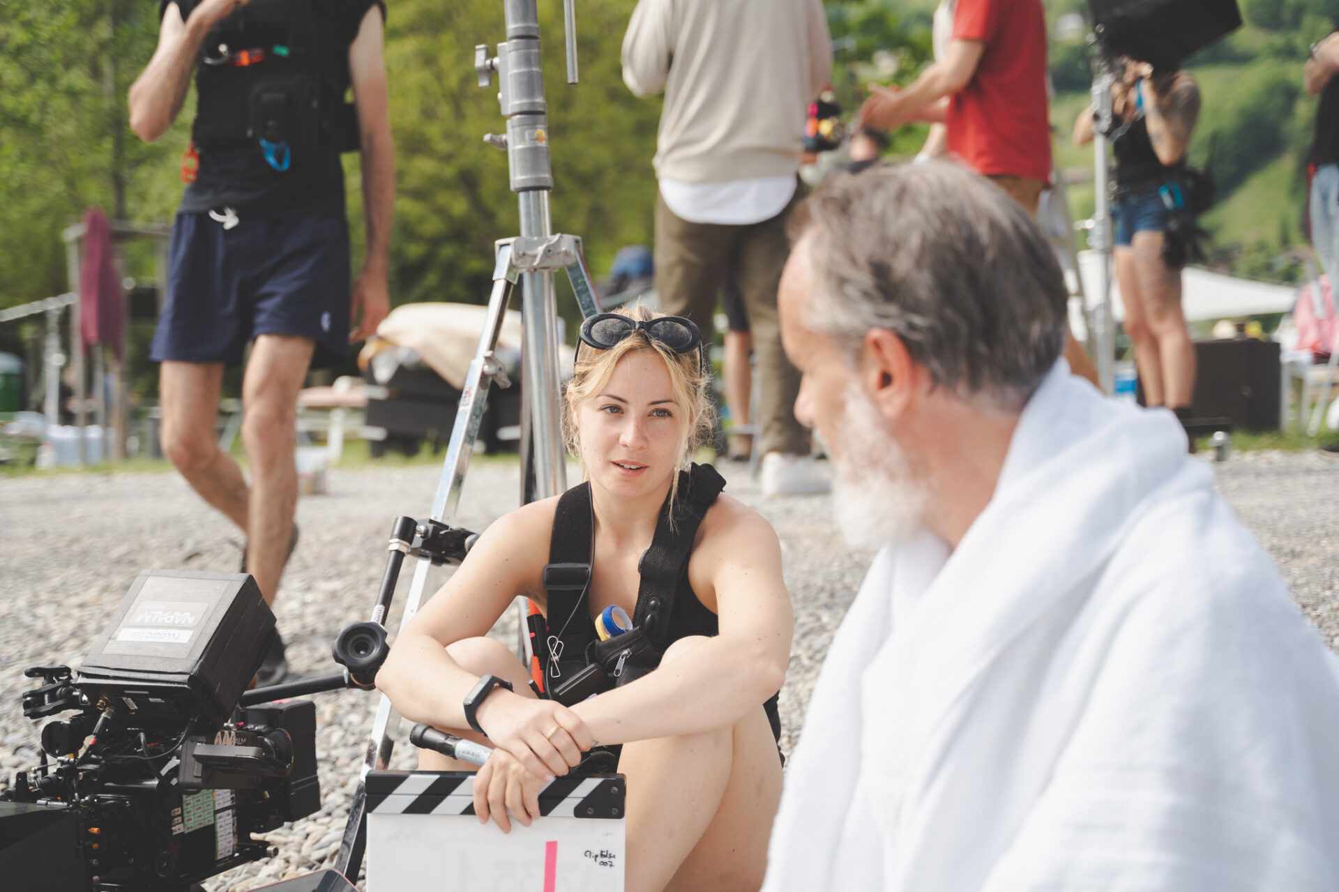 Director and lead actor in white robe in conversation between takes on a Swiss alpine gravel set